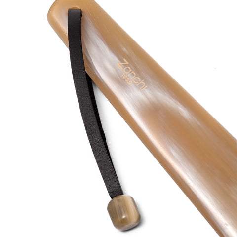 Close-up of luxury handcrafted shoehorn with leather lace and natural horn stopper – Italian craftsmanship
